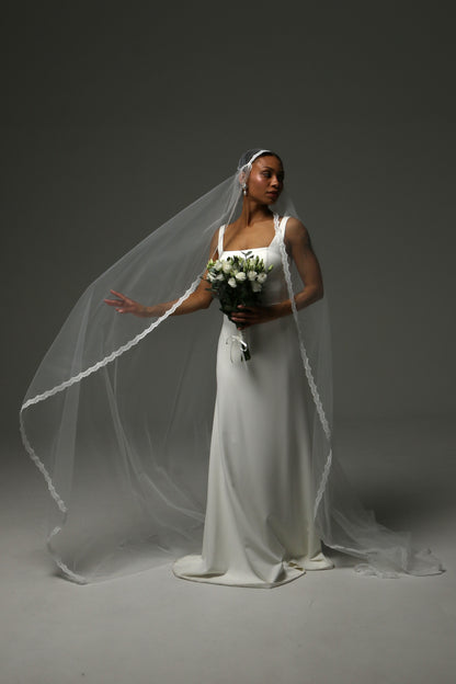 Bride wearing a Juliet cap cathedral veil with delicate lace edge.