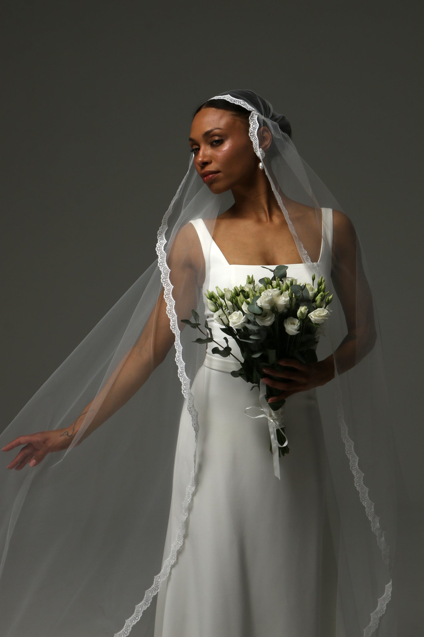 Side profile of a bride wearing a soft tulle cathedral veil.
