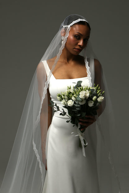 Romantic Juliet cap veil draped gracefully over a wedding gown.