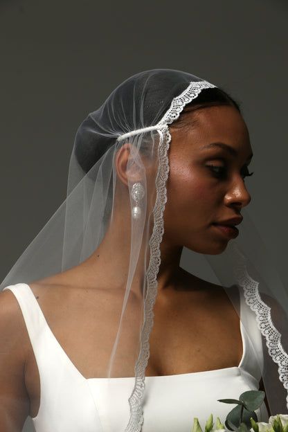Elegant bridal accessory featuring cathedral length and lace trim.