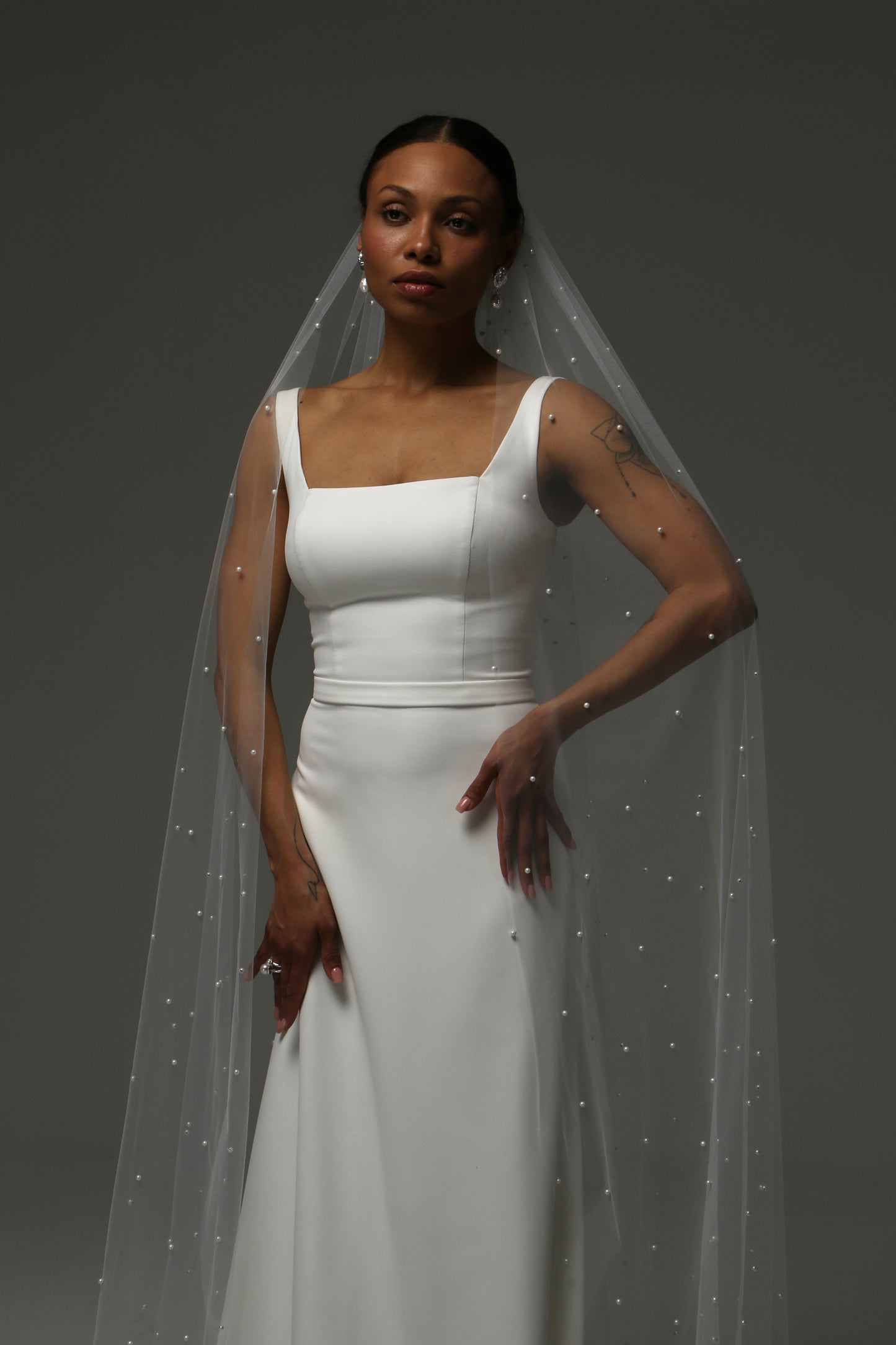 Cathedral-length wedding veil with scattered pearl embellishments on soft tulle.