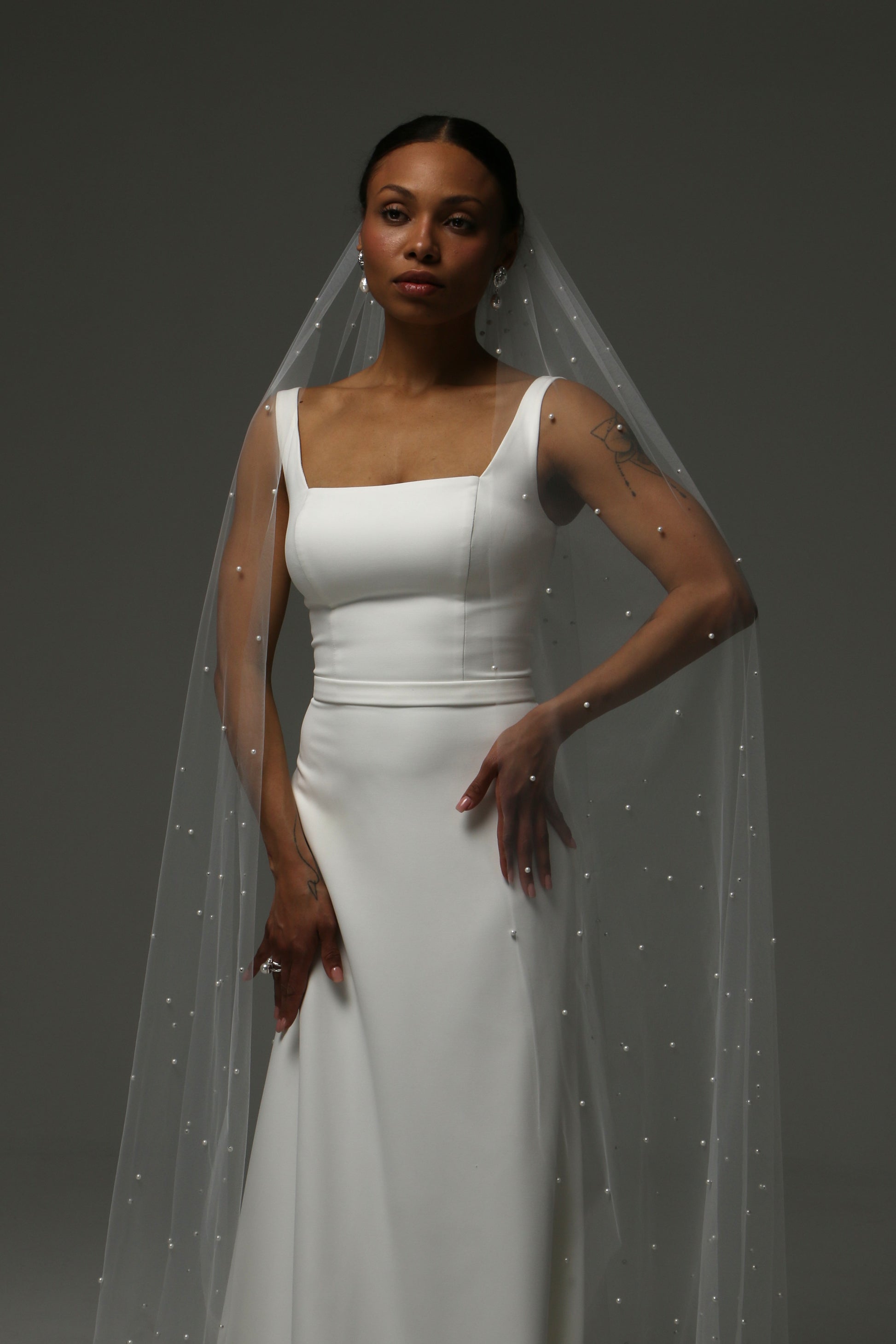 Cathedral-length wedding veil with scattered pearl embellishments on soft tulle.