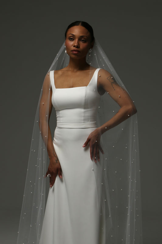 Cathedral-length wedding veil with scattered pearl embellishments on soft tulle.