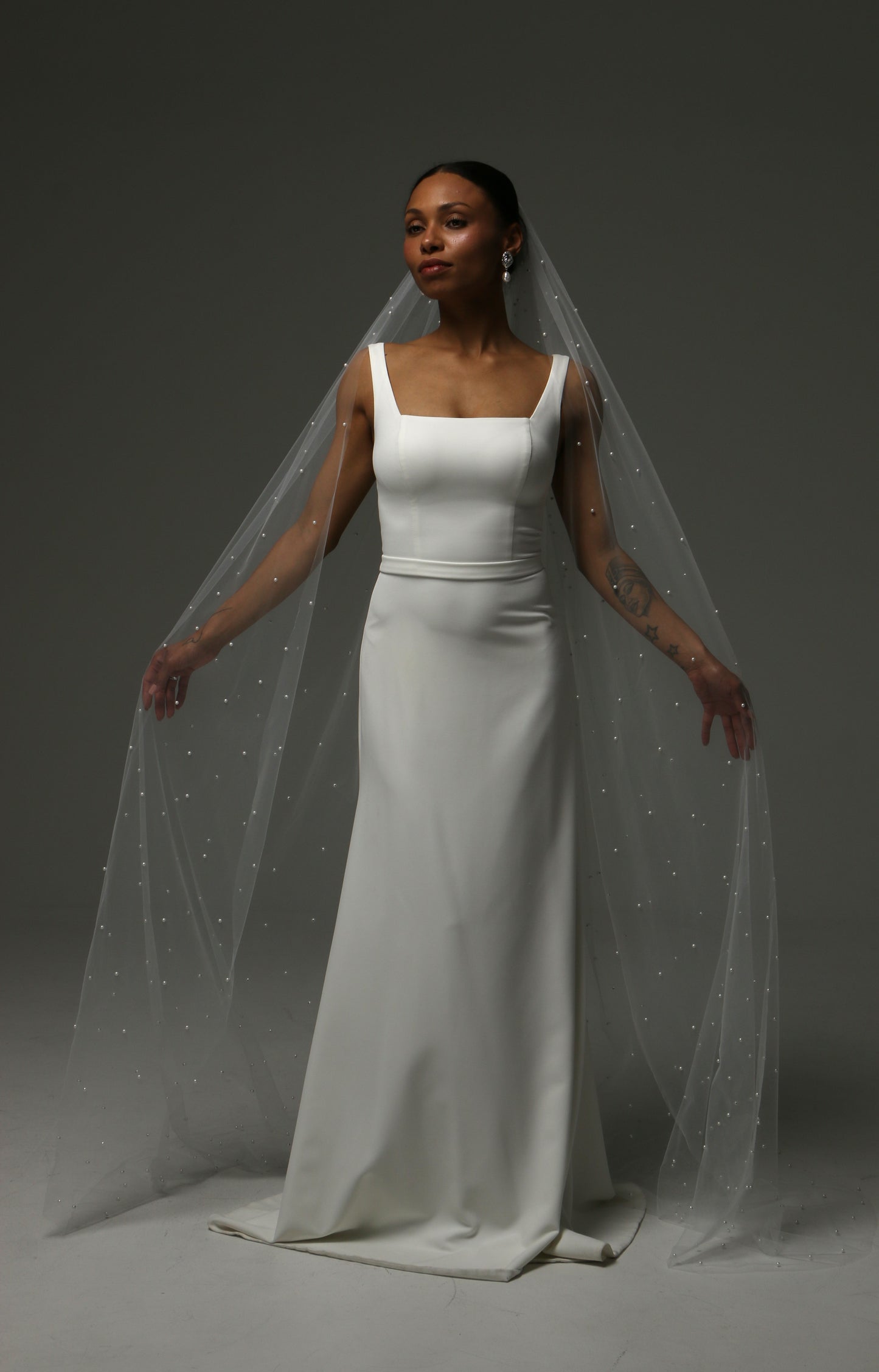 Soft illusion tulle wedding veil featuring scattered pearls throughout.