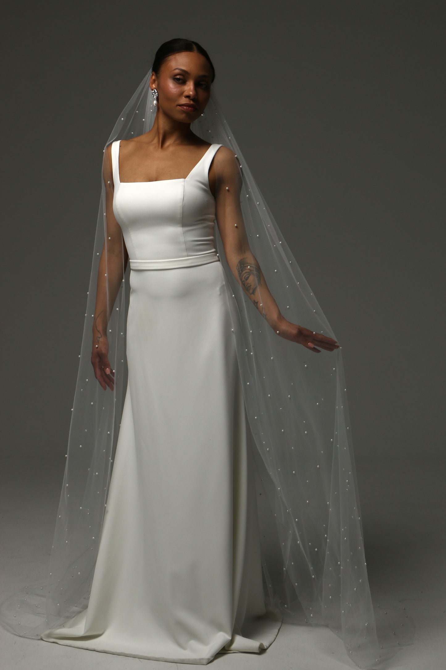 Bride wearing a cathedral-length pearl veil with flowing silhouette.