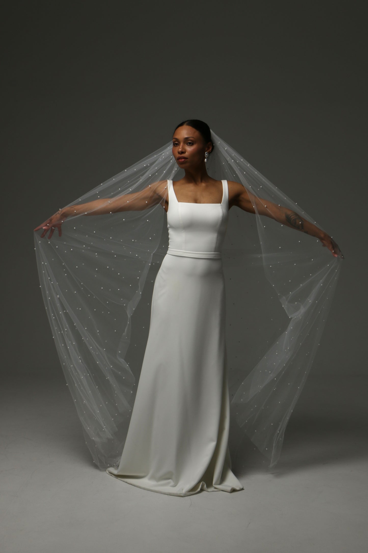 Modern bridal veil featuring scattered pearls and elegant drape.