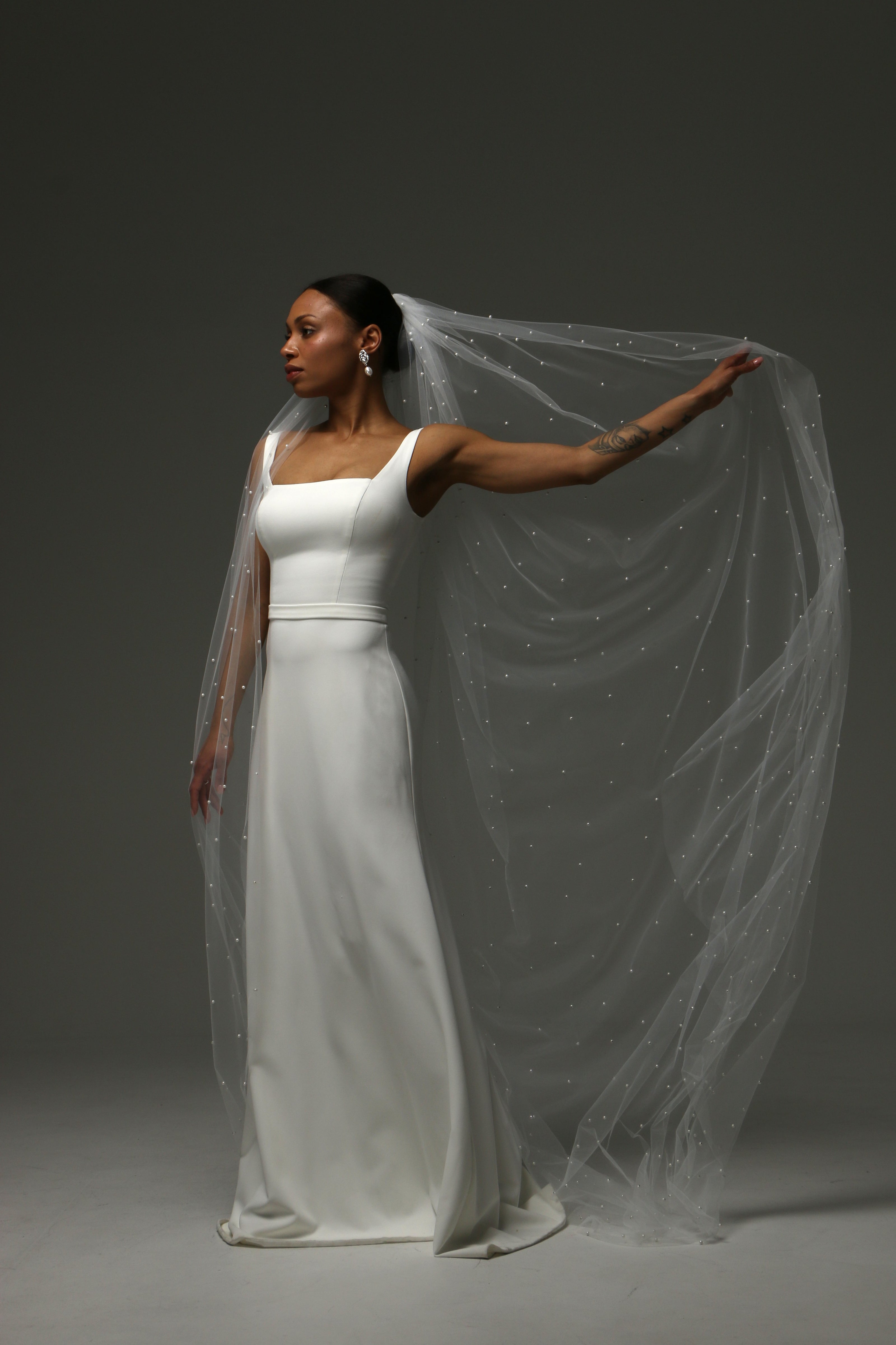 Timeless cathedral wedding veil with refined pearl detailing.