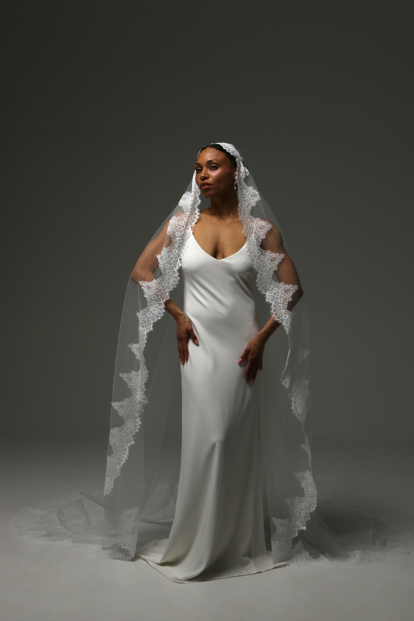 Cathedral mantilla wedding veil with floral lace appliqué edge in ivory tulle.