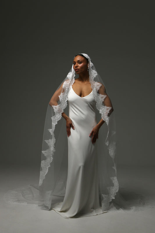 Cathedral mantilla wedding veil with floral lace appliqué edge in ivory tulle.