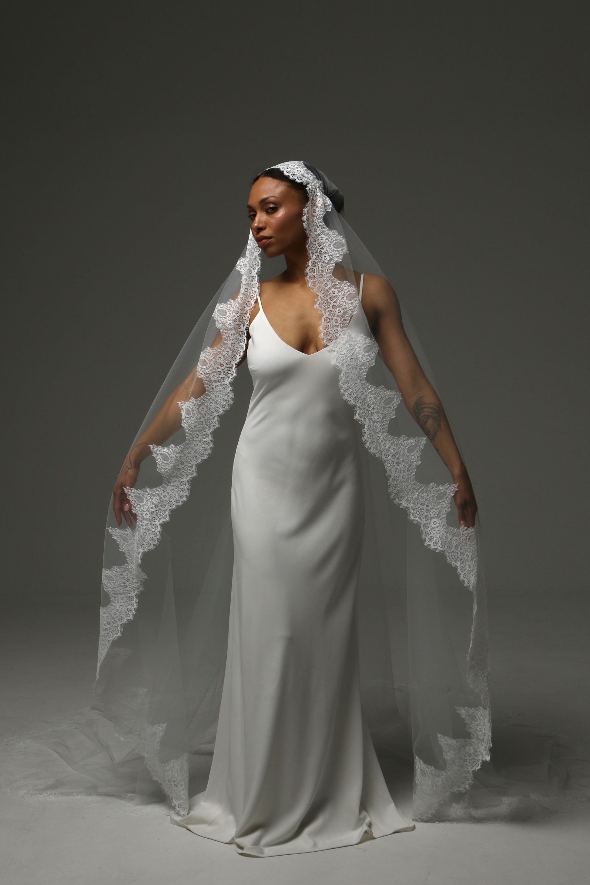 ride wearing a cathedral-length mantilla veil with intricate lace border.
