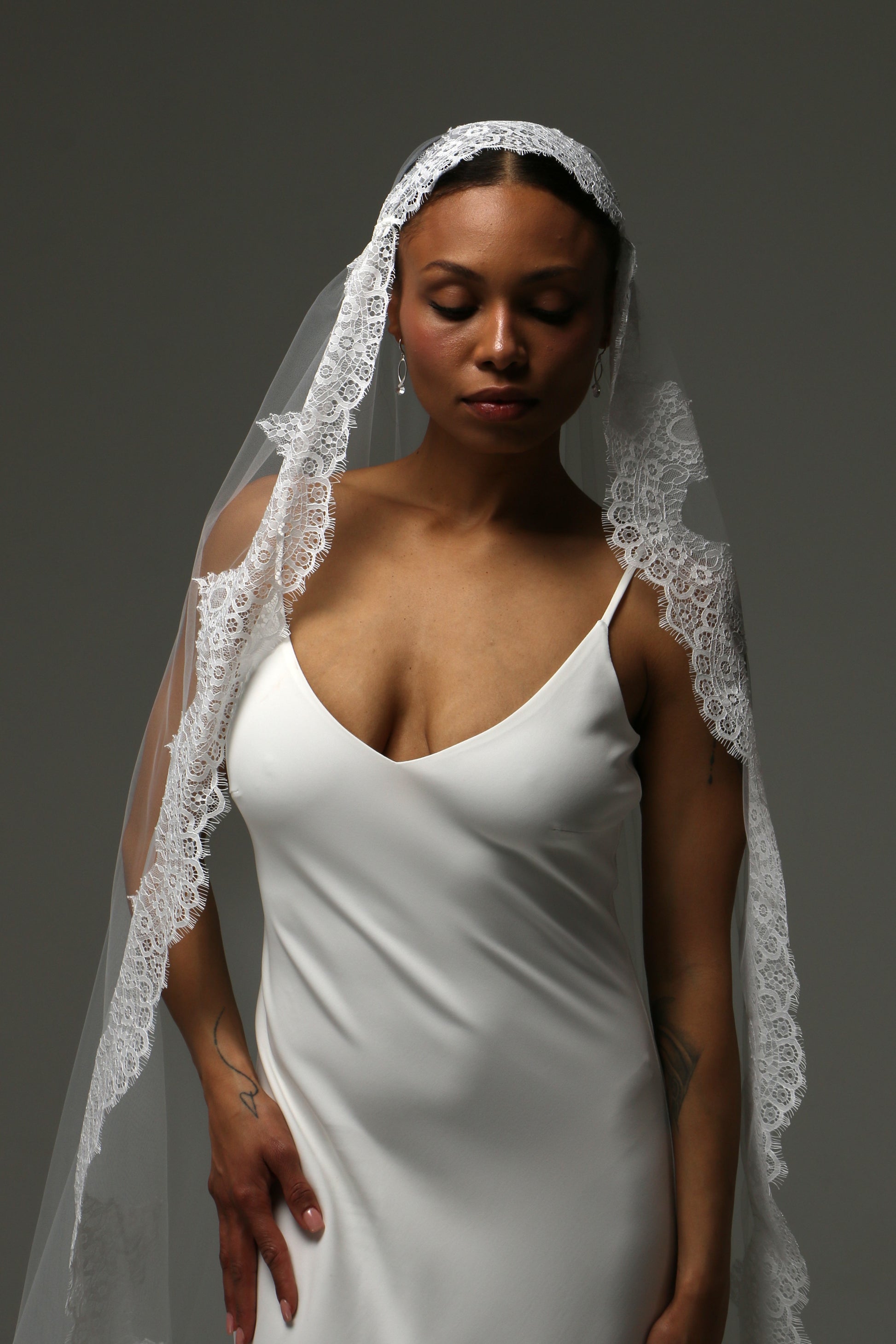 Romantic wedding veil framing the bride with floral lace details.