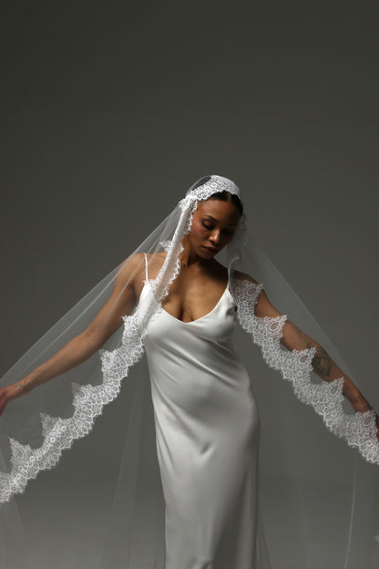 Elegant bridal accessory featuring cathedral length and floral lace trim.