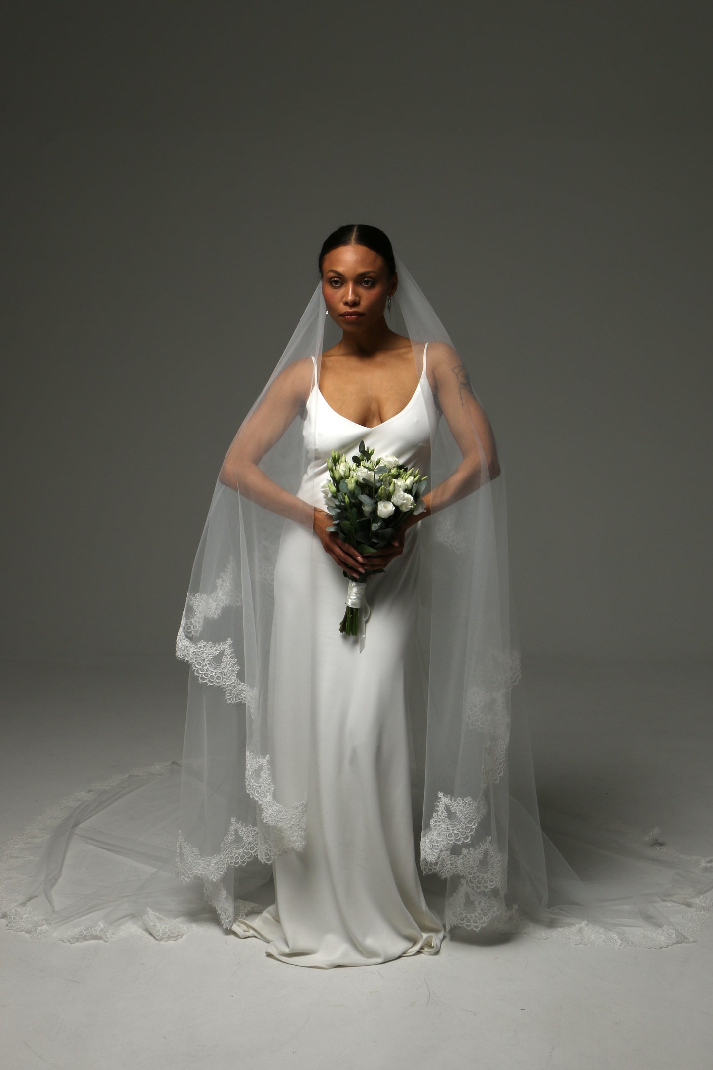 Bride wearing a two-tier veil with traditional blusher layer.