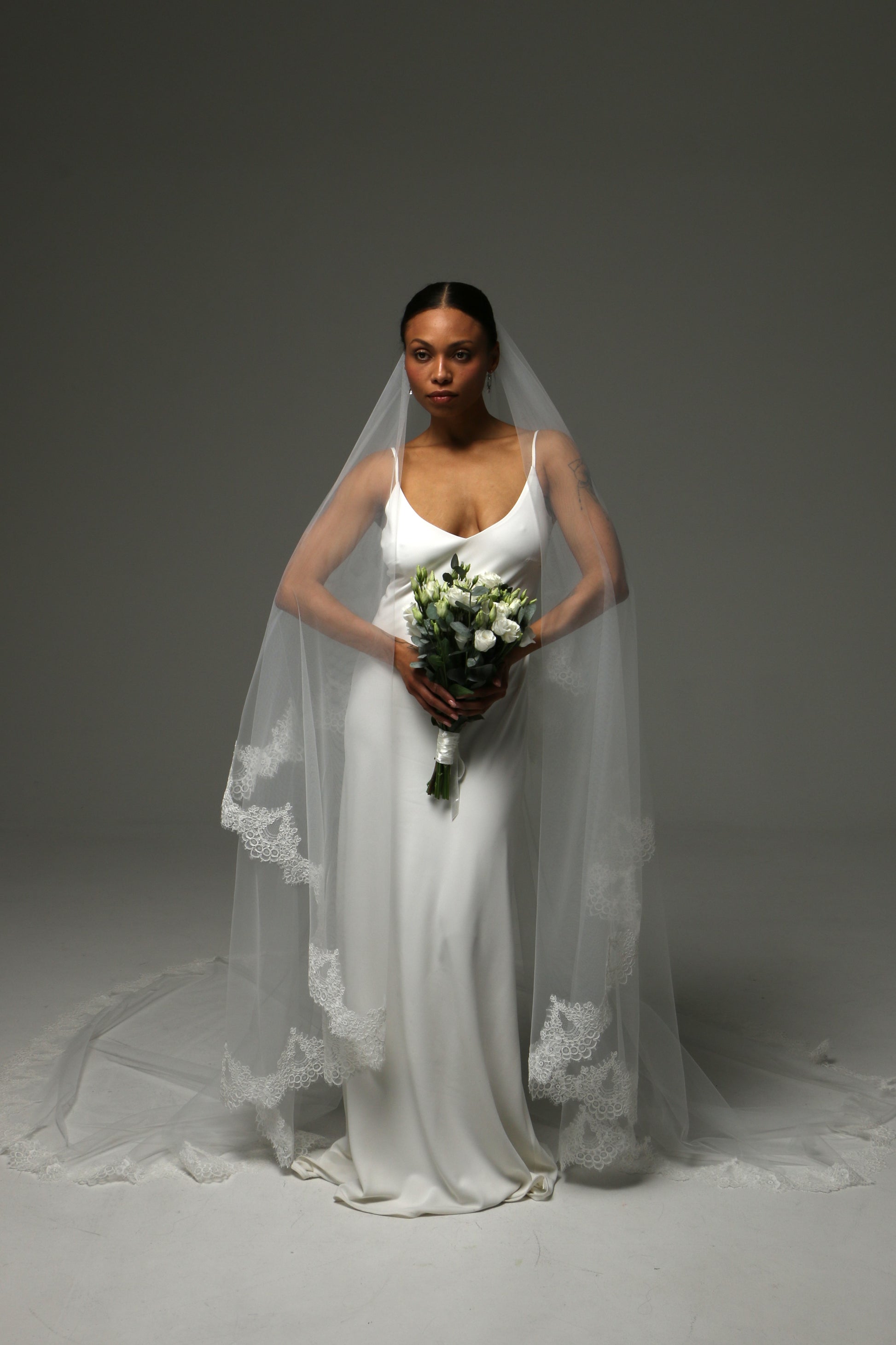 Bride wearing a two-tier veil with traditional blusher layer.