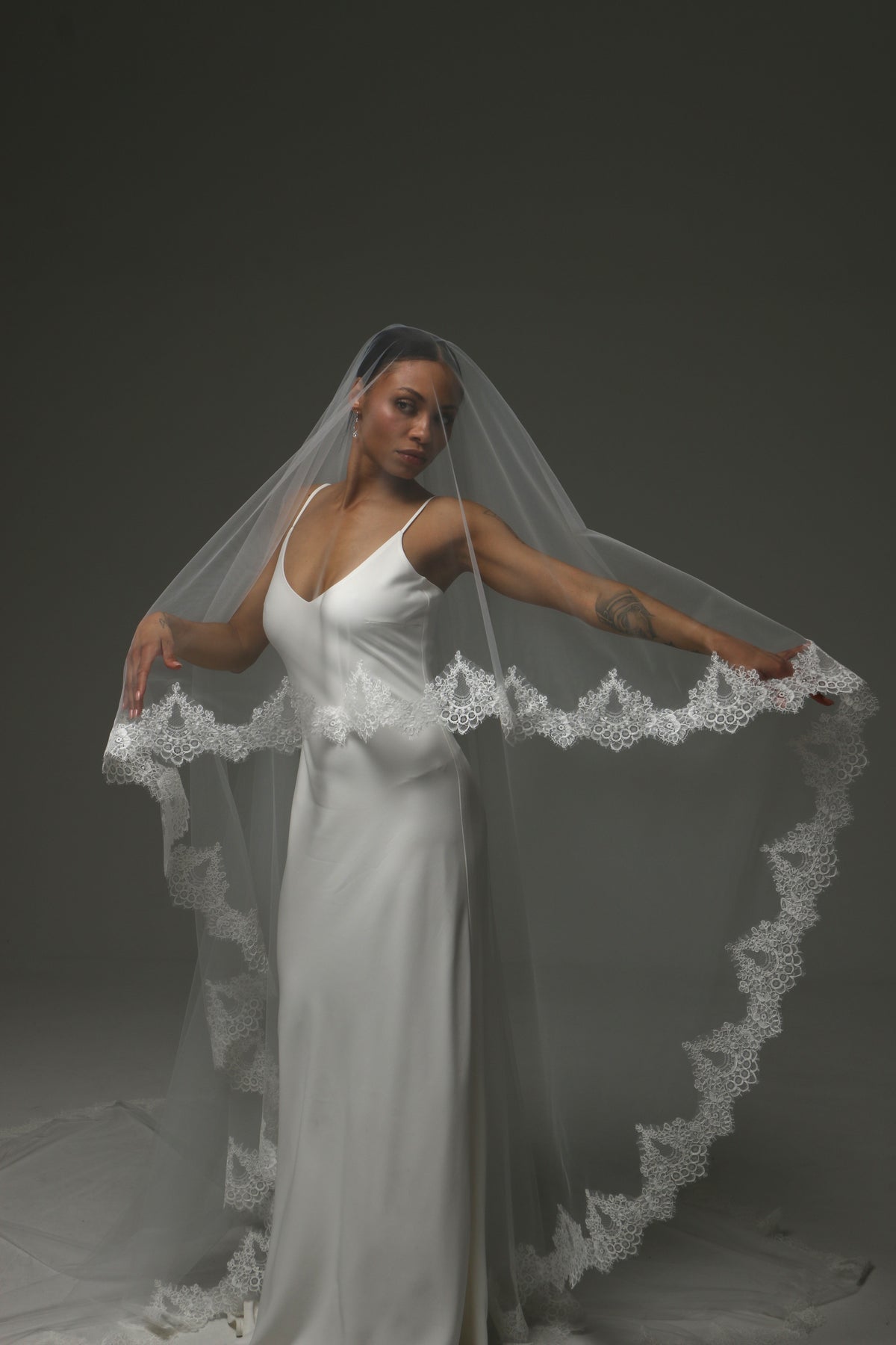 Cathedral wedding veil with ornate lace edging and soft tulle.