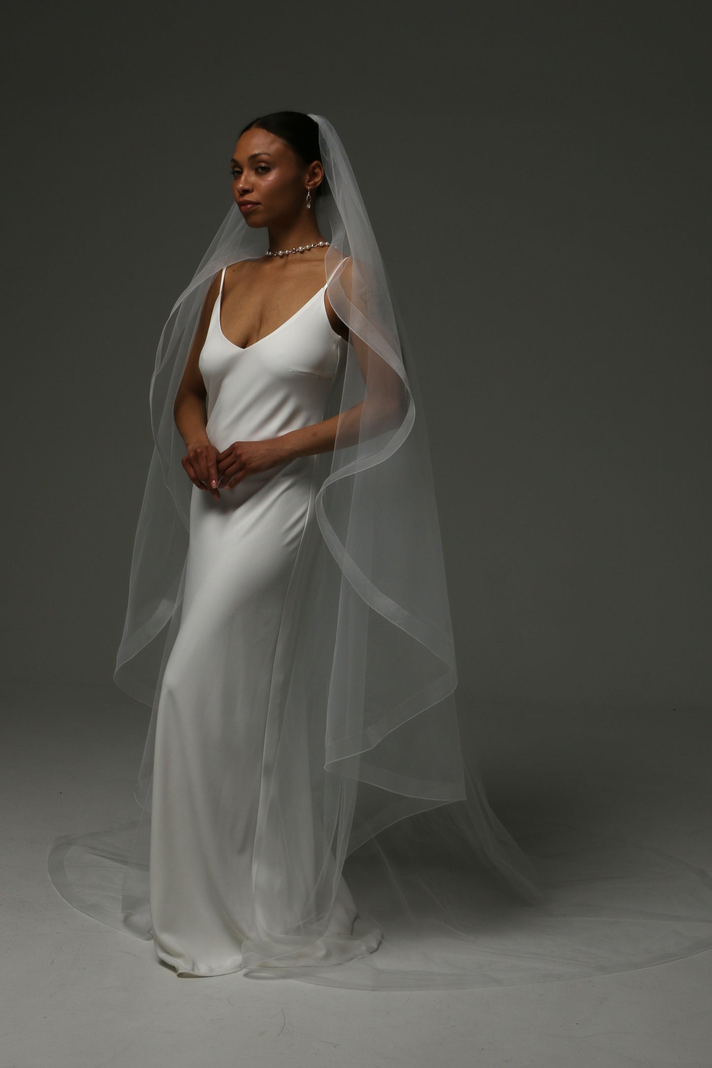 Bride wearing a one-tier cascade veil with horsehair edging.