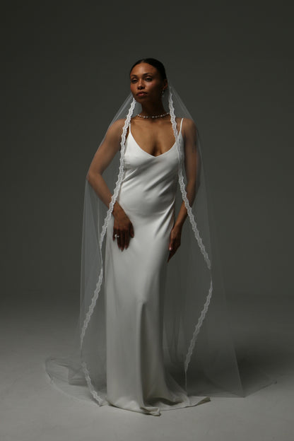 Elegant cathedral-length bridal veil featuring delicate lace trim.