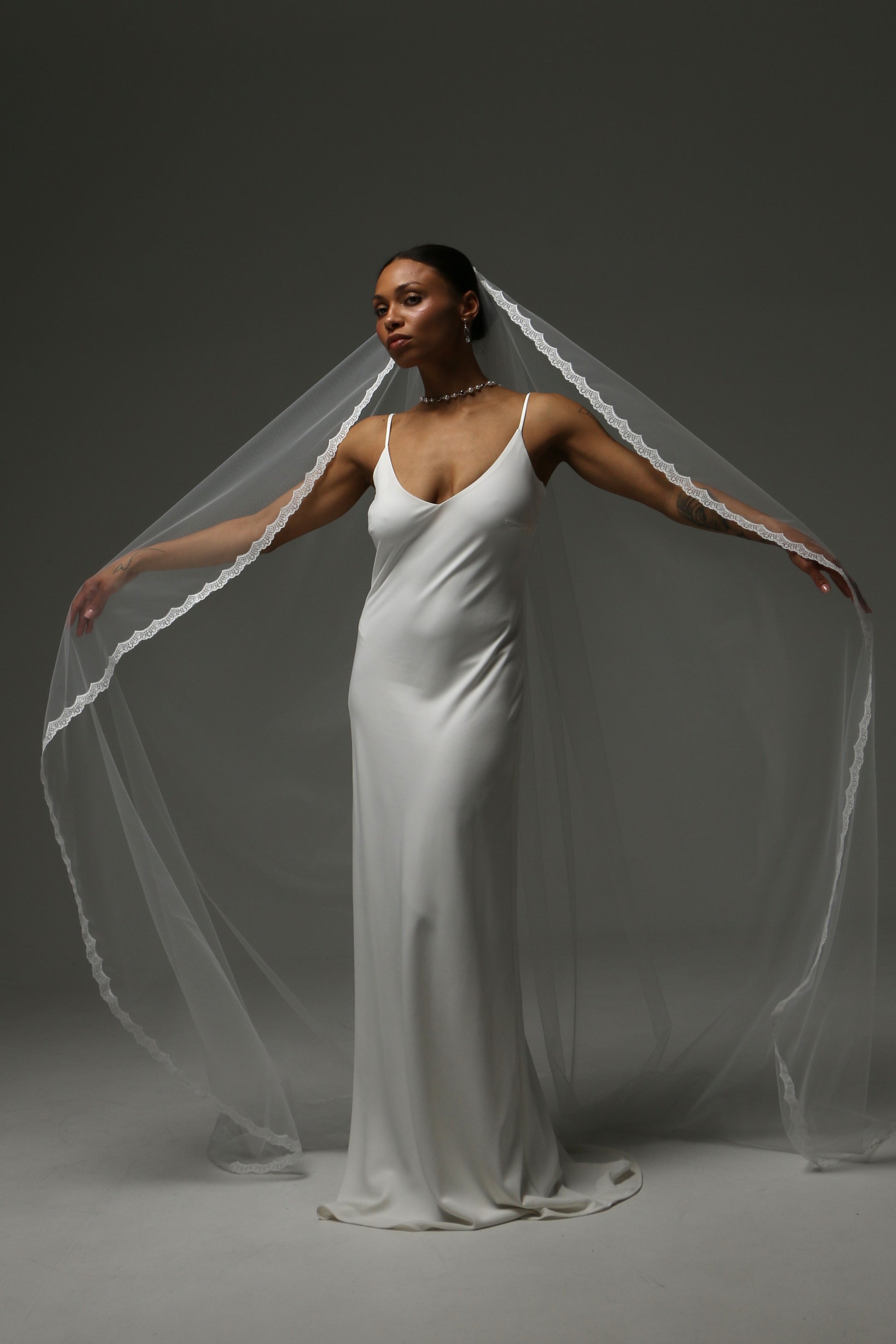 One-tier cathedral wedding veil with thin lace edge and soft illusion tulle.