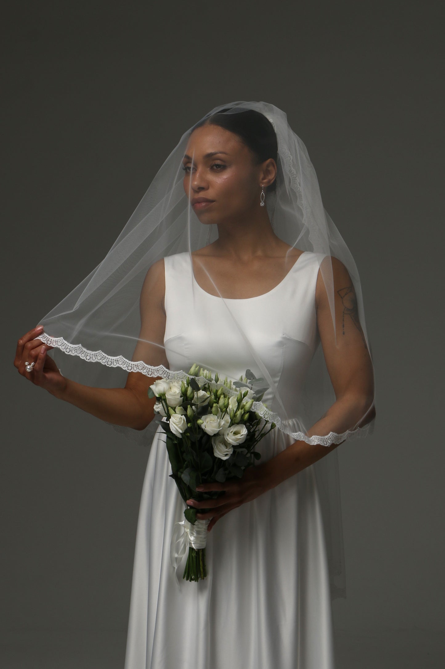 Short bridal veil with blusher layer and delicate lace border.