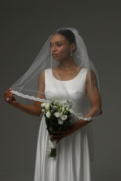 Short bridal veil with blusher layer and delicate lace border.