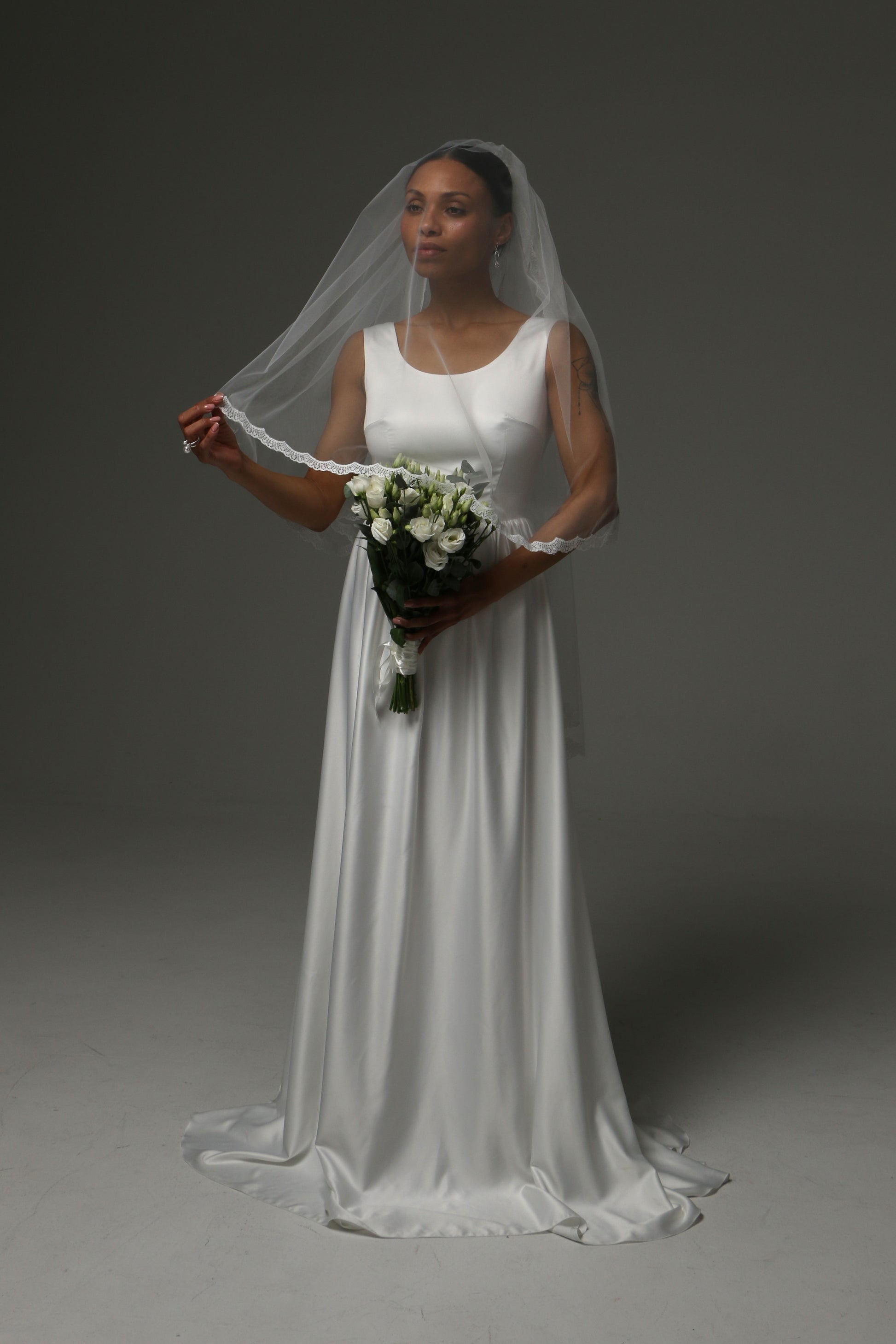 Delicate lace-edged wedding veil with airy silhouette.