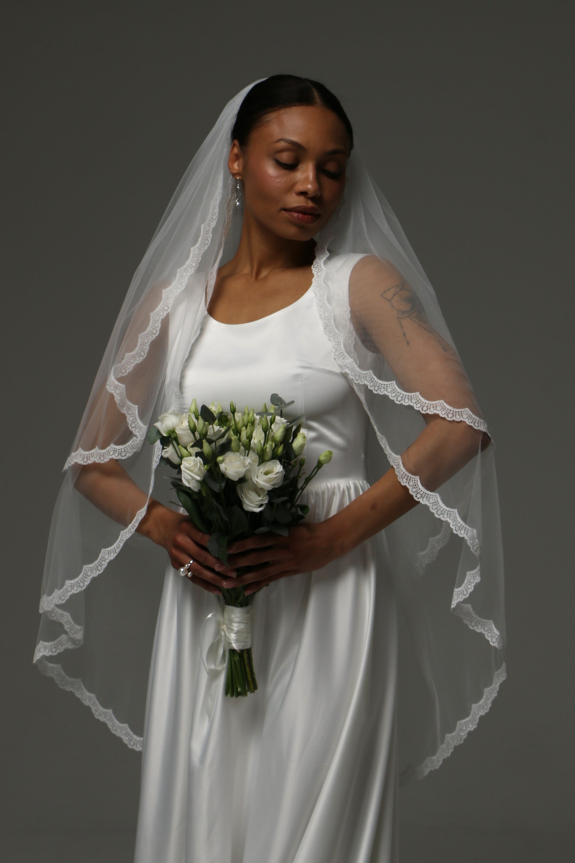 Two-tier short wedding veil with delicate lace edge and blusher.