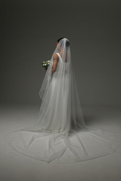 Bride wearing a one-tier cascade veil with subtle pencil trim.