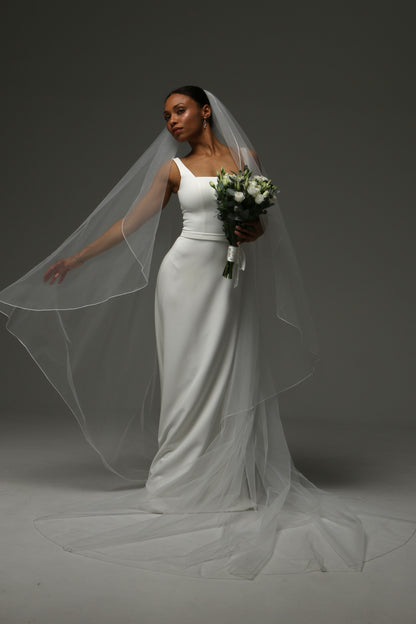 Elegant cascade veil with soft flowing cathedral-length train.