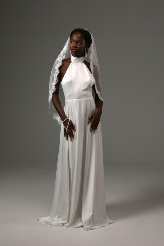 Fingertip wedding veil with dotted tulle and delicate lace edge.