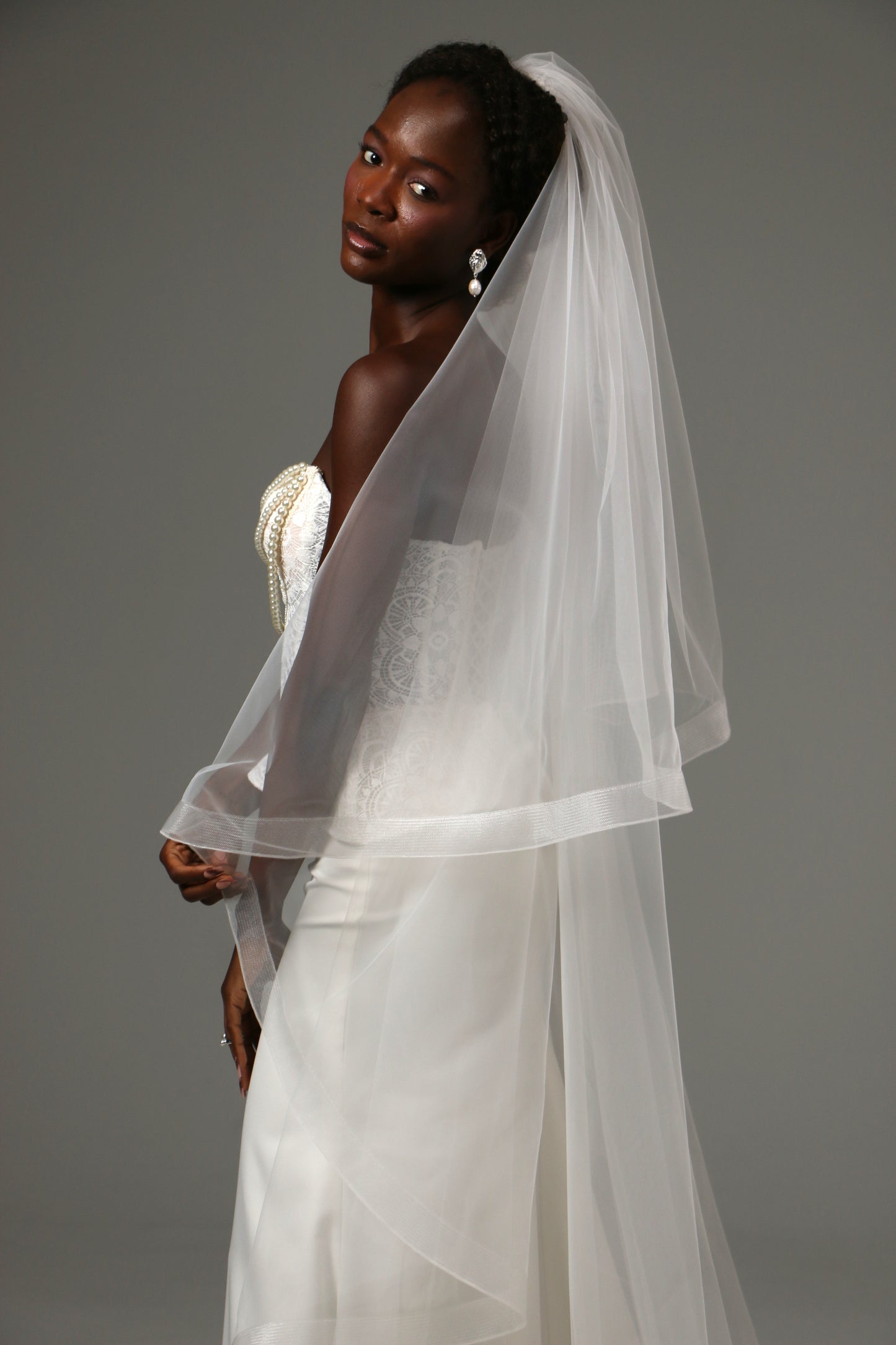 Two-tier wedding veil with graceful drape and defined edge.