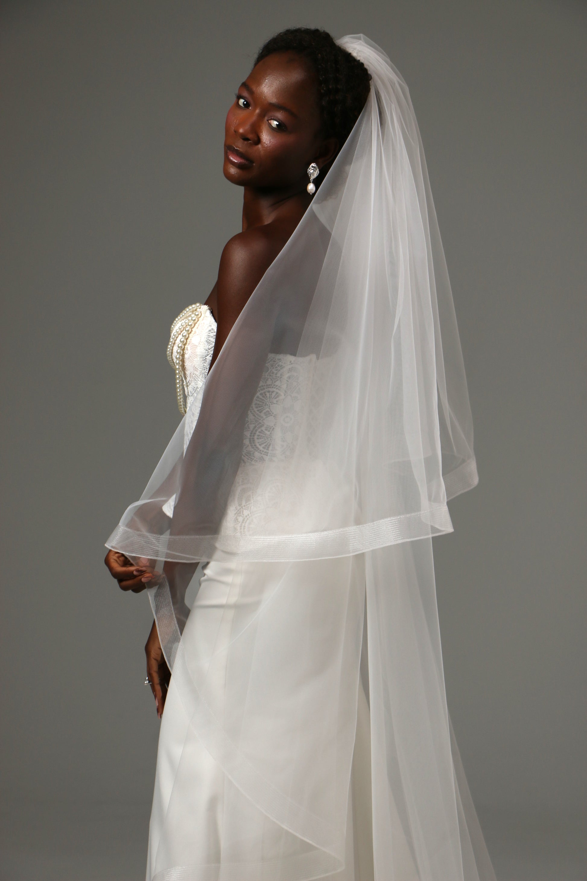 Two-tier wedding veil with graceful drape and defined edge.