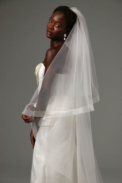 Two-tier wedding veil with graceful drape and defined edge.