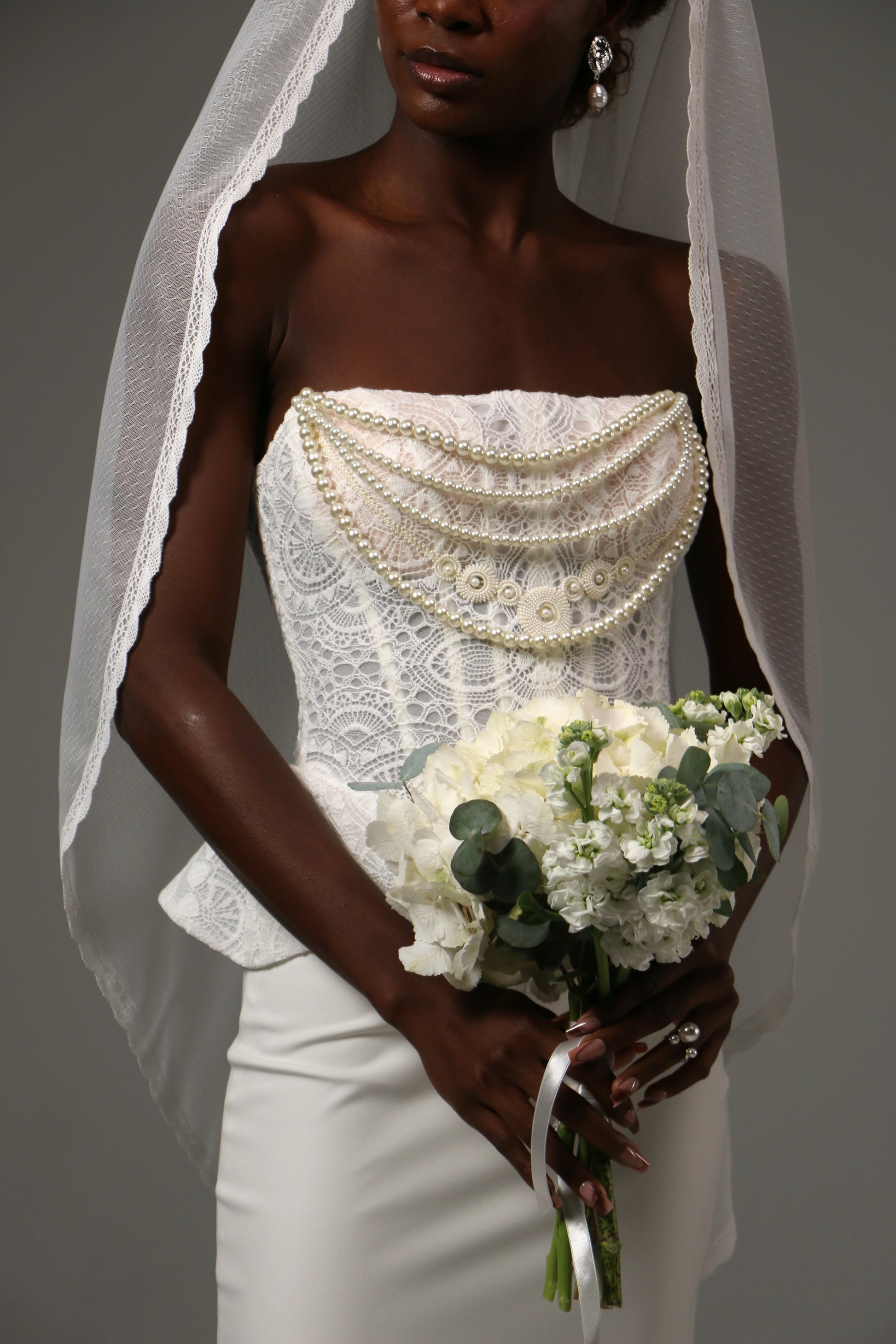 Close-up of lace edge trim on a dotted tulle wedding veil.