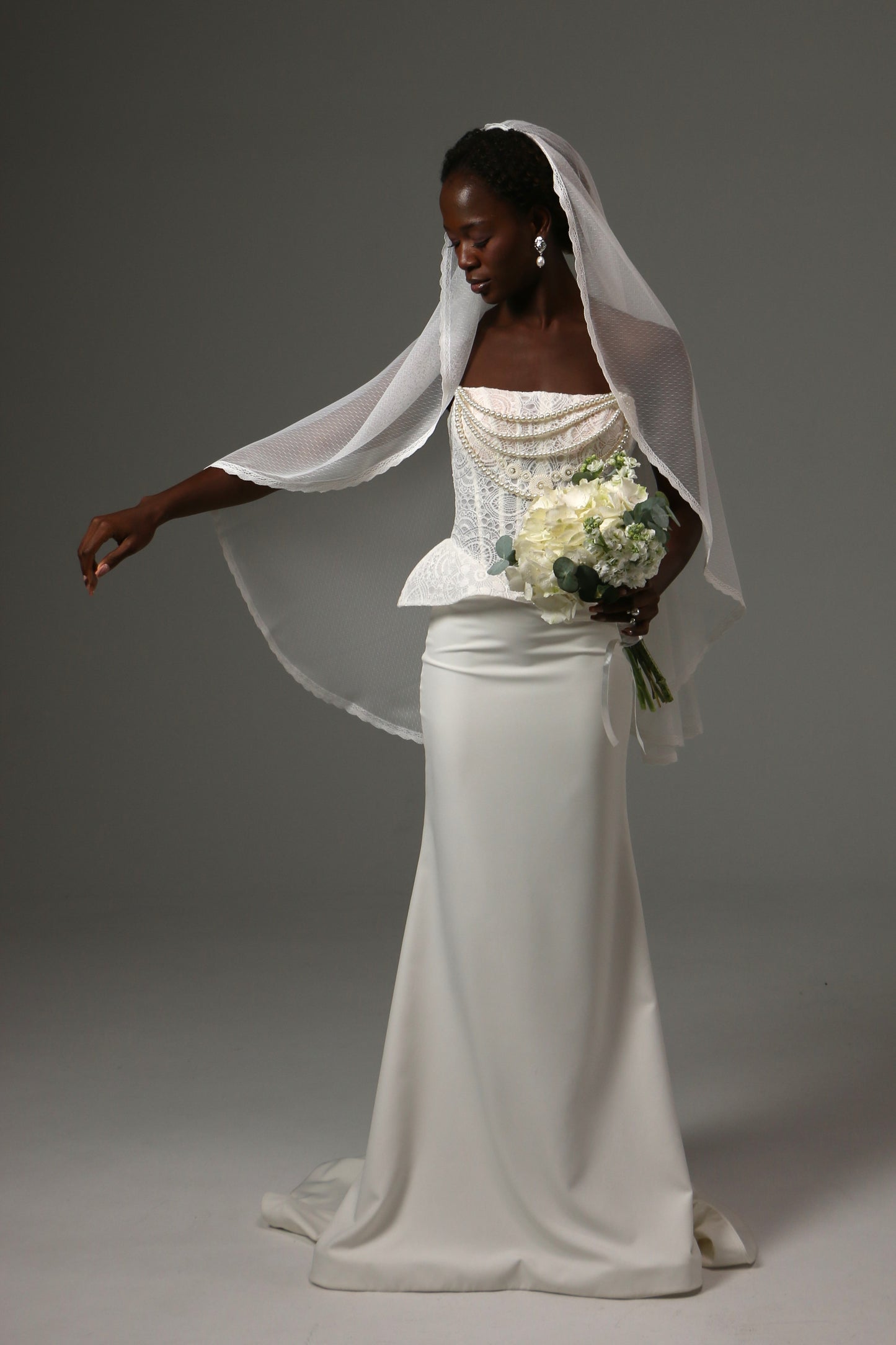 Fingertip-length wedding veil with elegant lace edging.