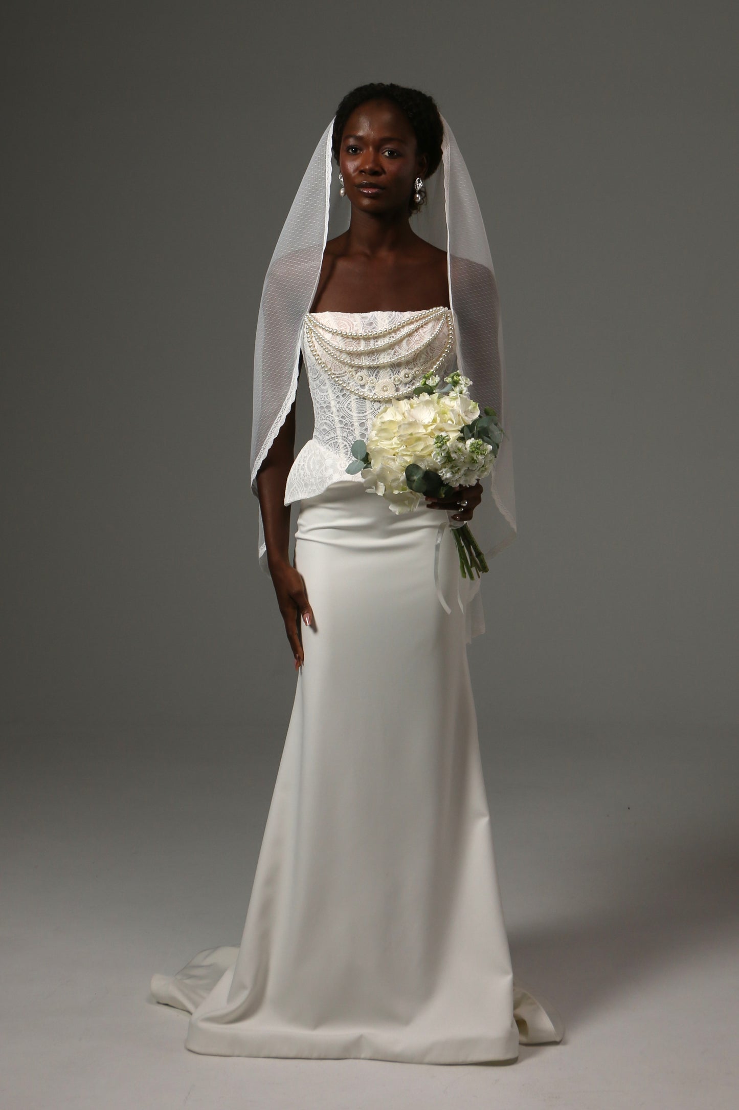 Bride wearing a fingertip veil crafted from soft dotted tulle.