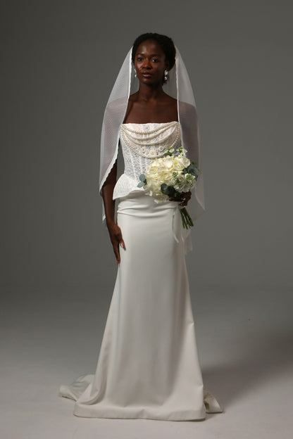 Bride wearing a fingertip veil crafted from soft dotted tulle.