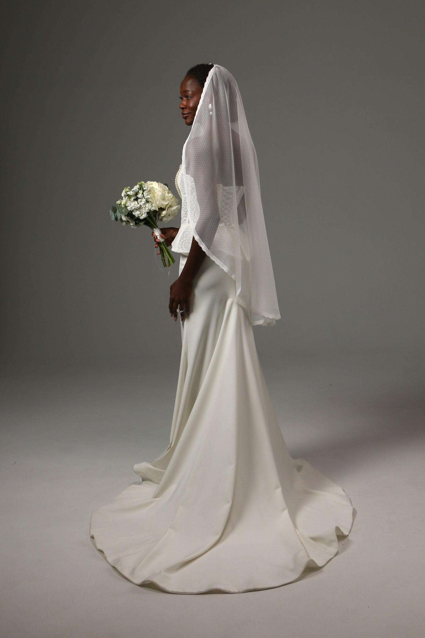Romantic bridal accessory with soft drape and dotted texture.