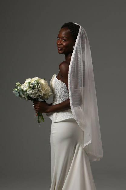 Handmade fingertip veil featuring delicate lace edging.