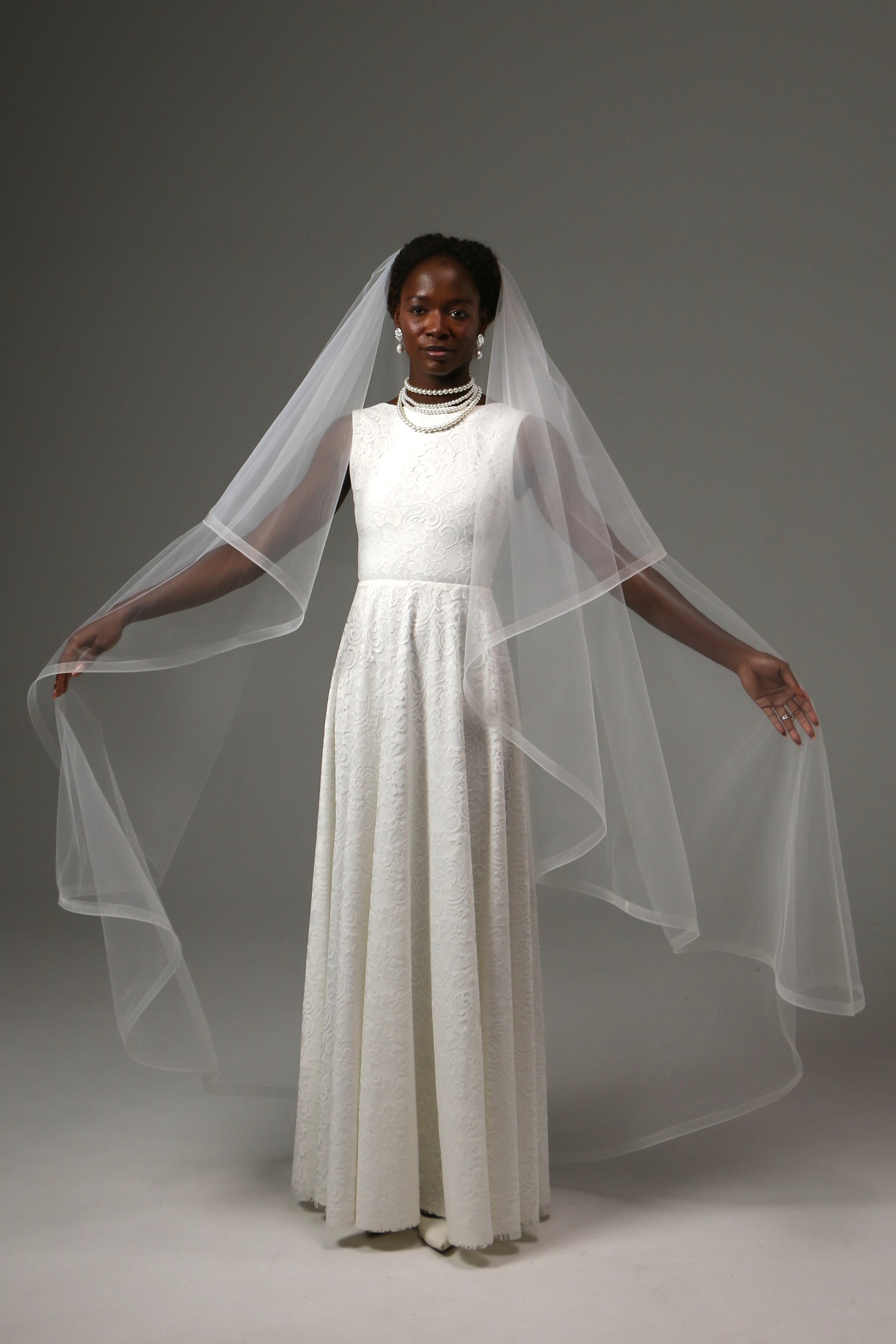 Bride wearing a waltz-length veil with elegant structured edge.