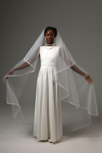 Bride wearing a waltz-length veil with elegant structured edge.