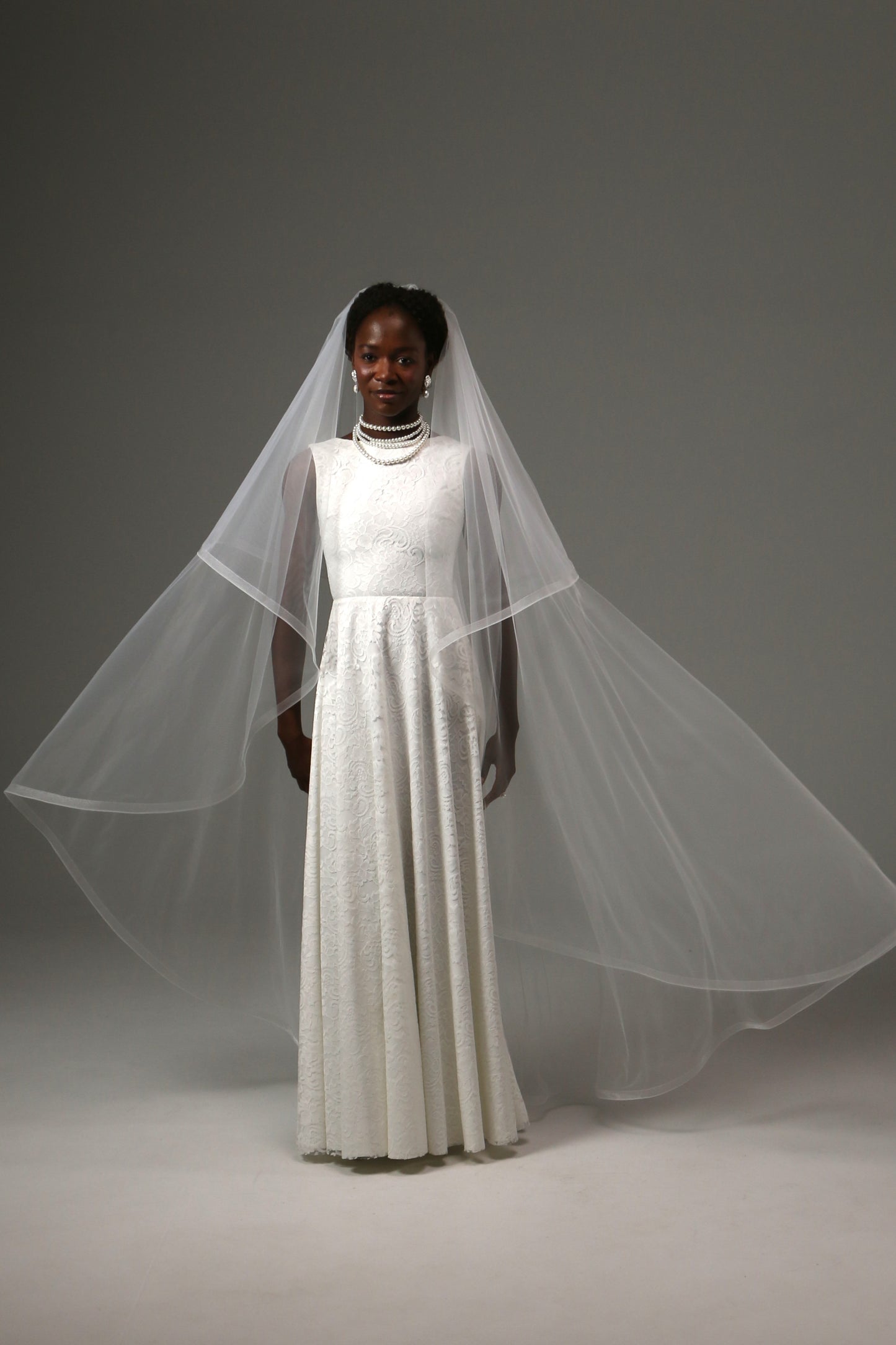 Romantic two-tier wedding veil featuring a traditional blusher.