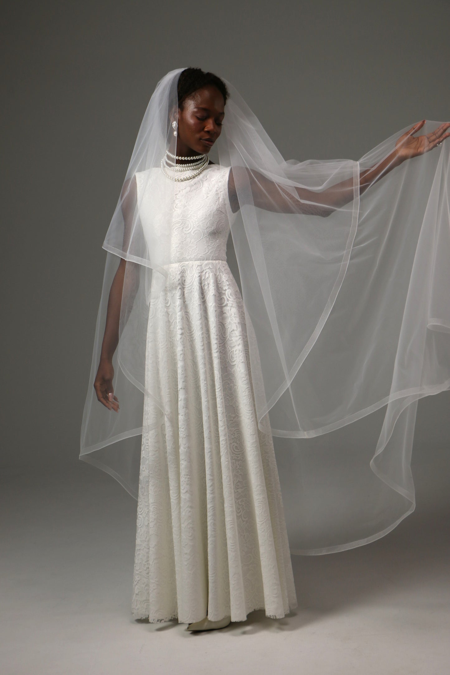 Elegant bridal accessory with flowing silhouette and blusher.