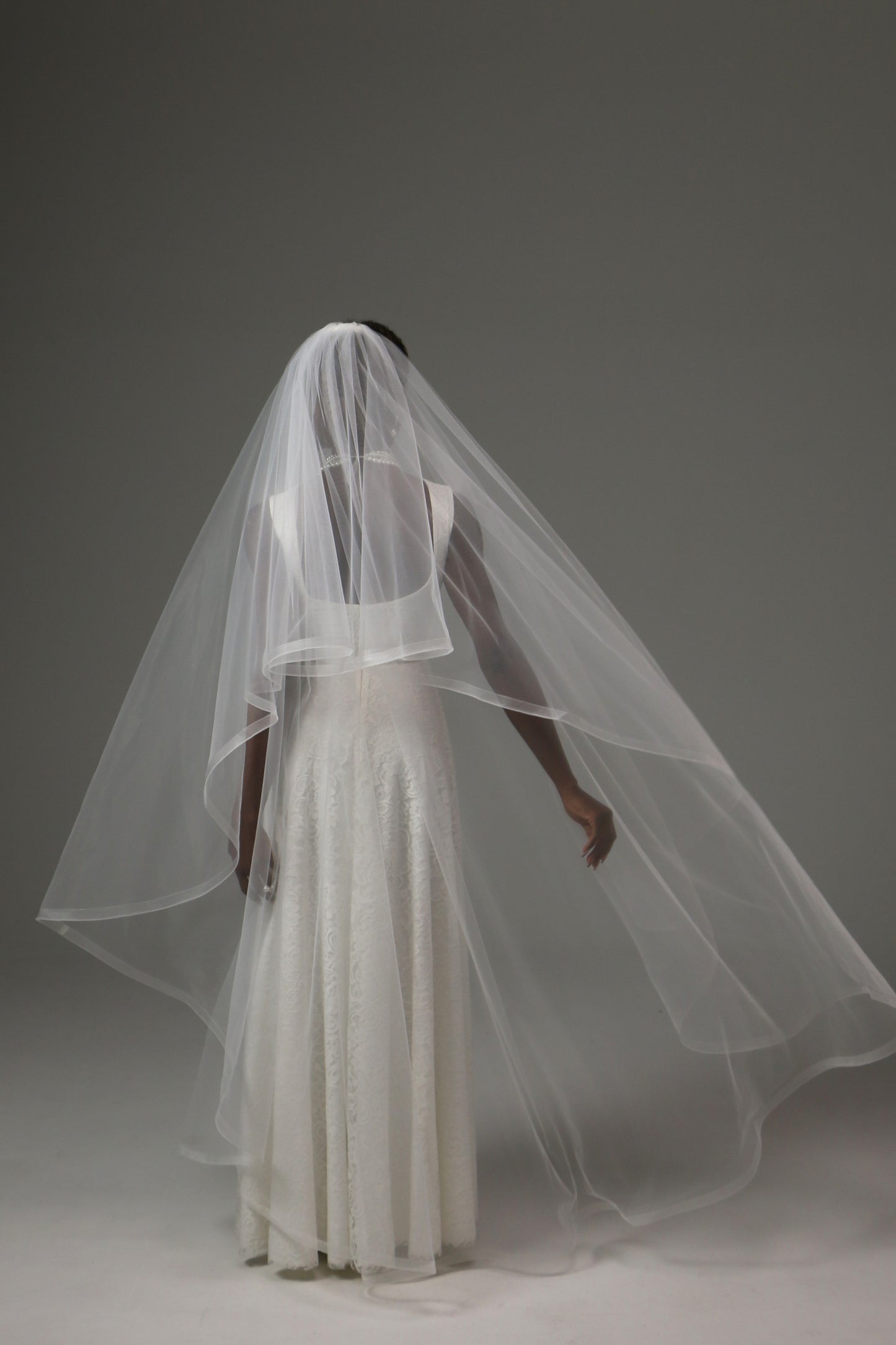 Bridal veil with traditional blusher and refined silhouette.