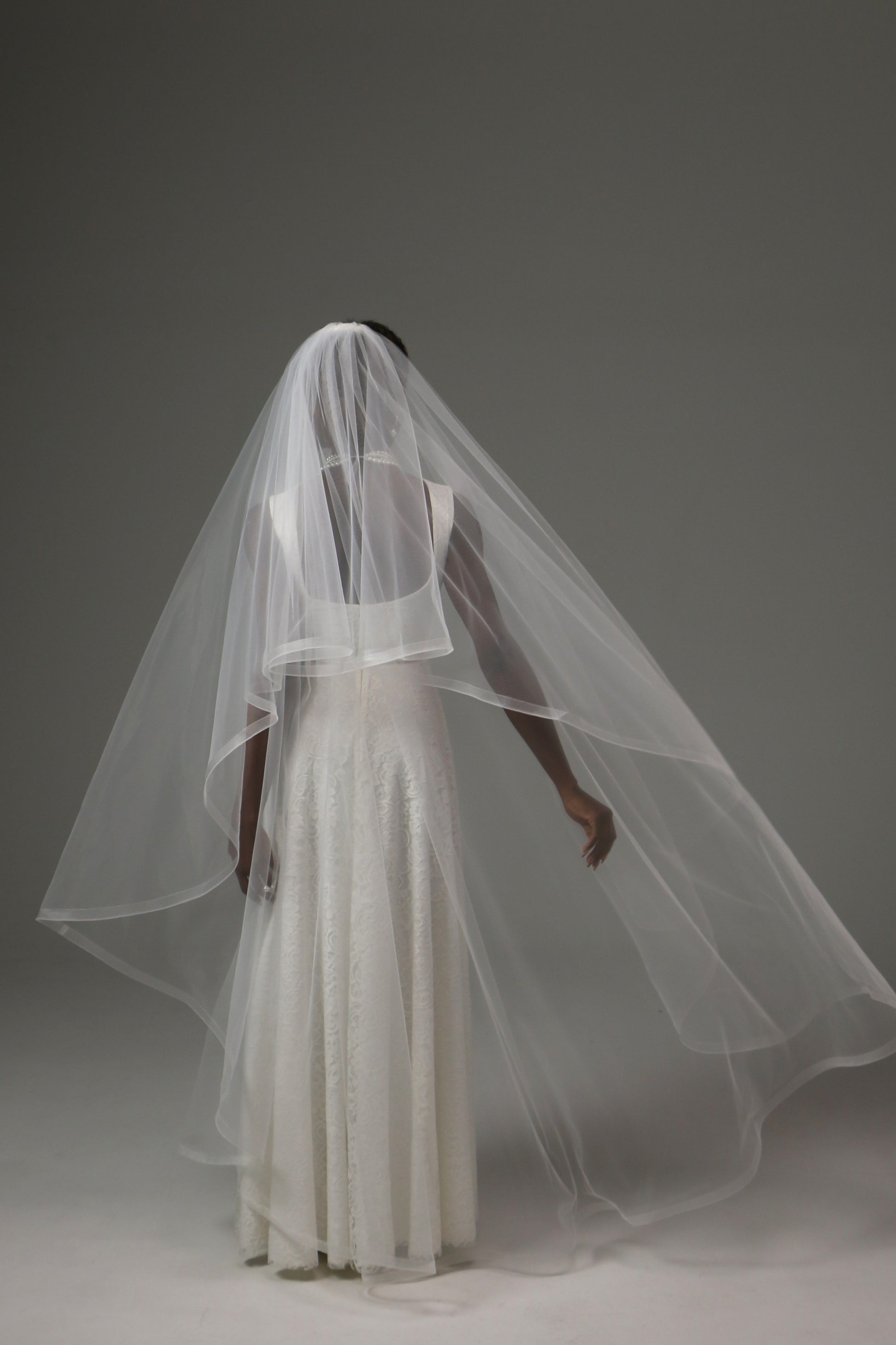 Bridal veil with traditional blusher and refined silhouette.
