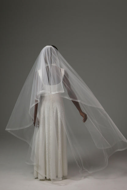 Bridal veil with traditional blusher and refined silhouette.