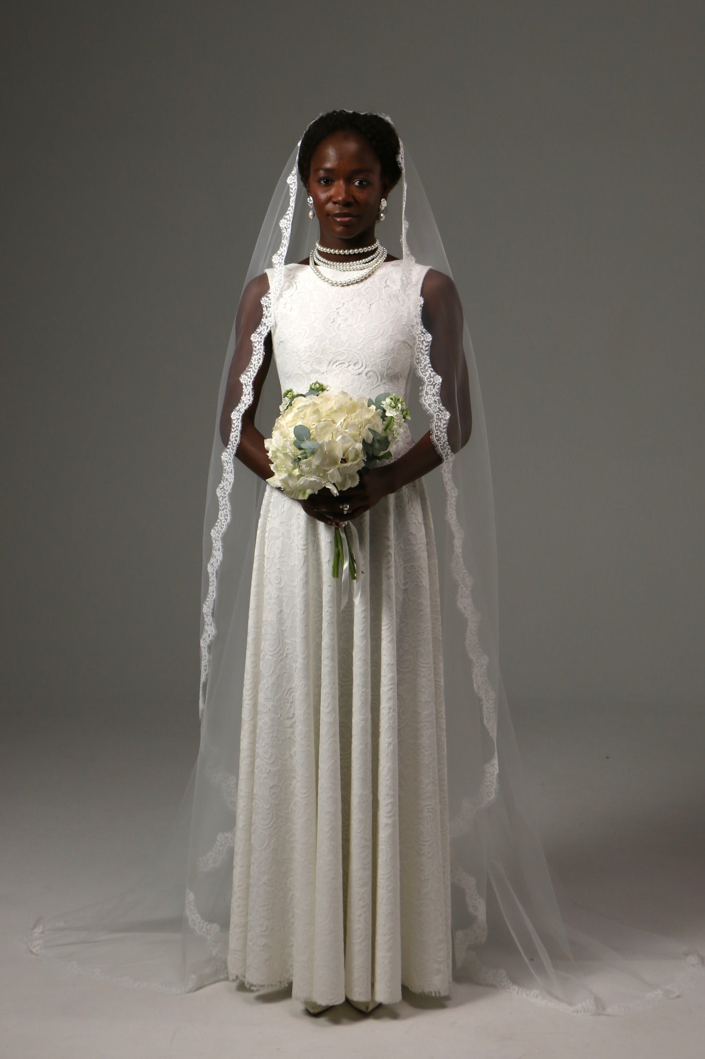 Bride wearing a one-tier mantilla veil crafted from soft tulle.