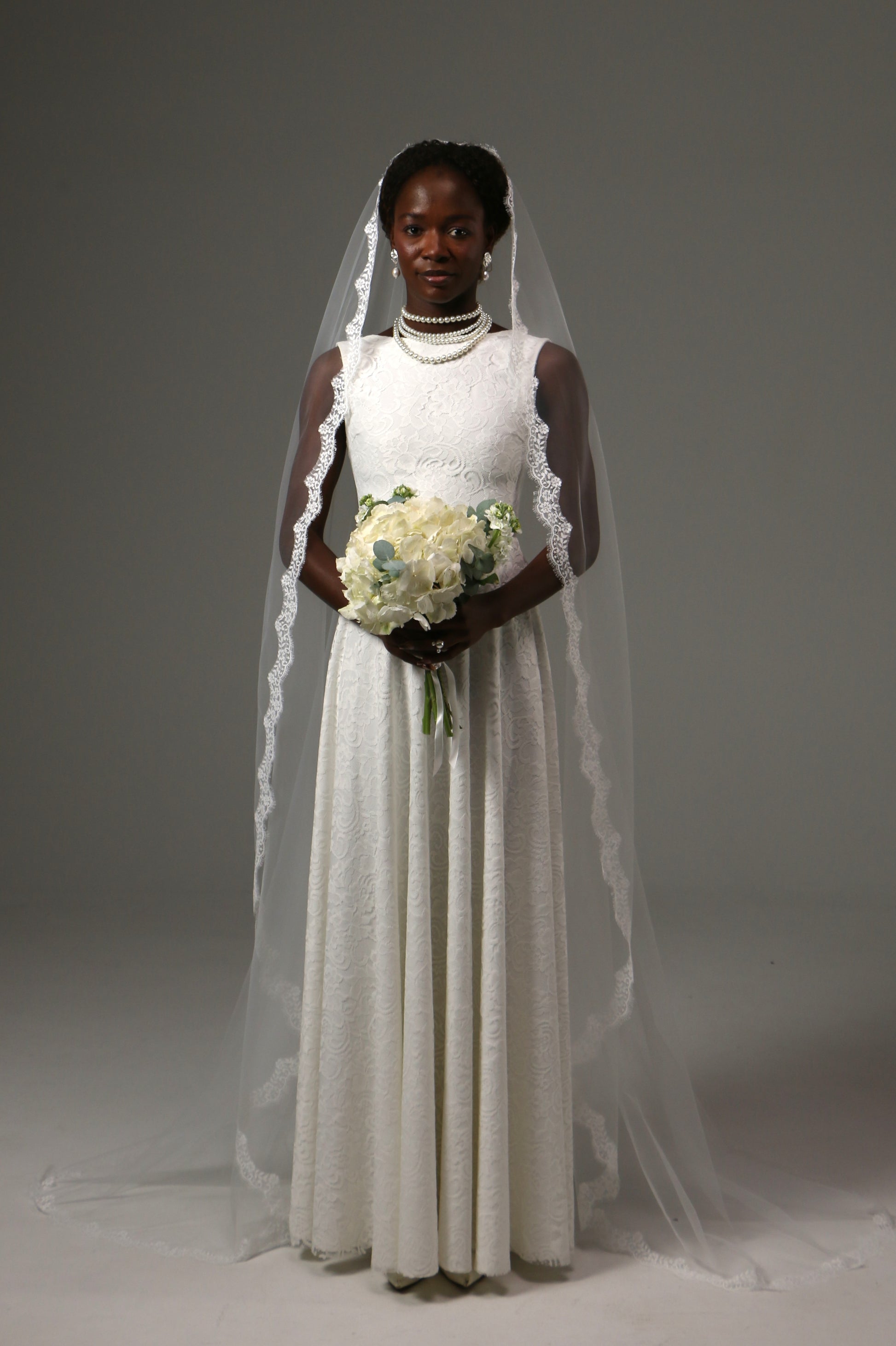 Bride wearing a one-tier mantilla veil crafted from soft tulle.