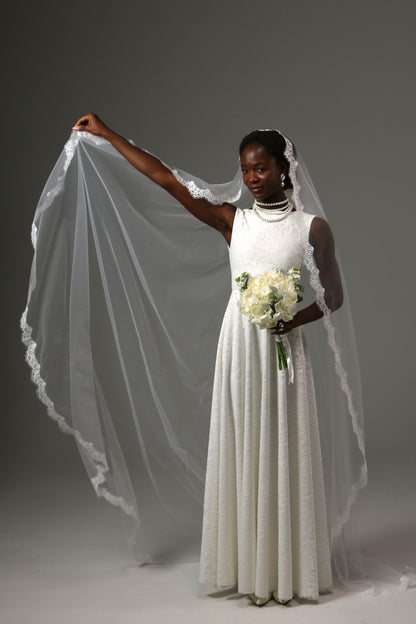 Traditional cathedral wedding veil featuring delicate lace trim.
