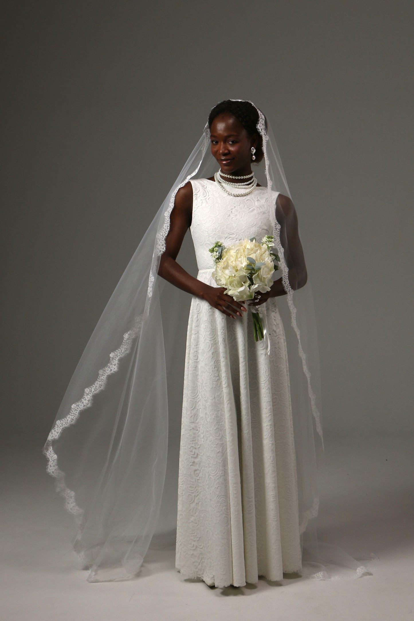 Lace-edged cathedral veil creating a romantic bridal look.