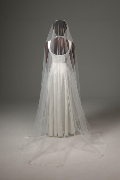Cathedral-length bridal veil with airy drape and lace trim.